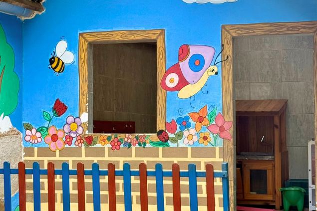 Casinha de brincar pintada, com cerca colorida