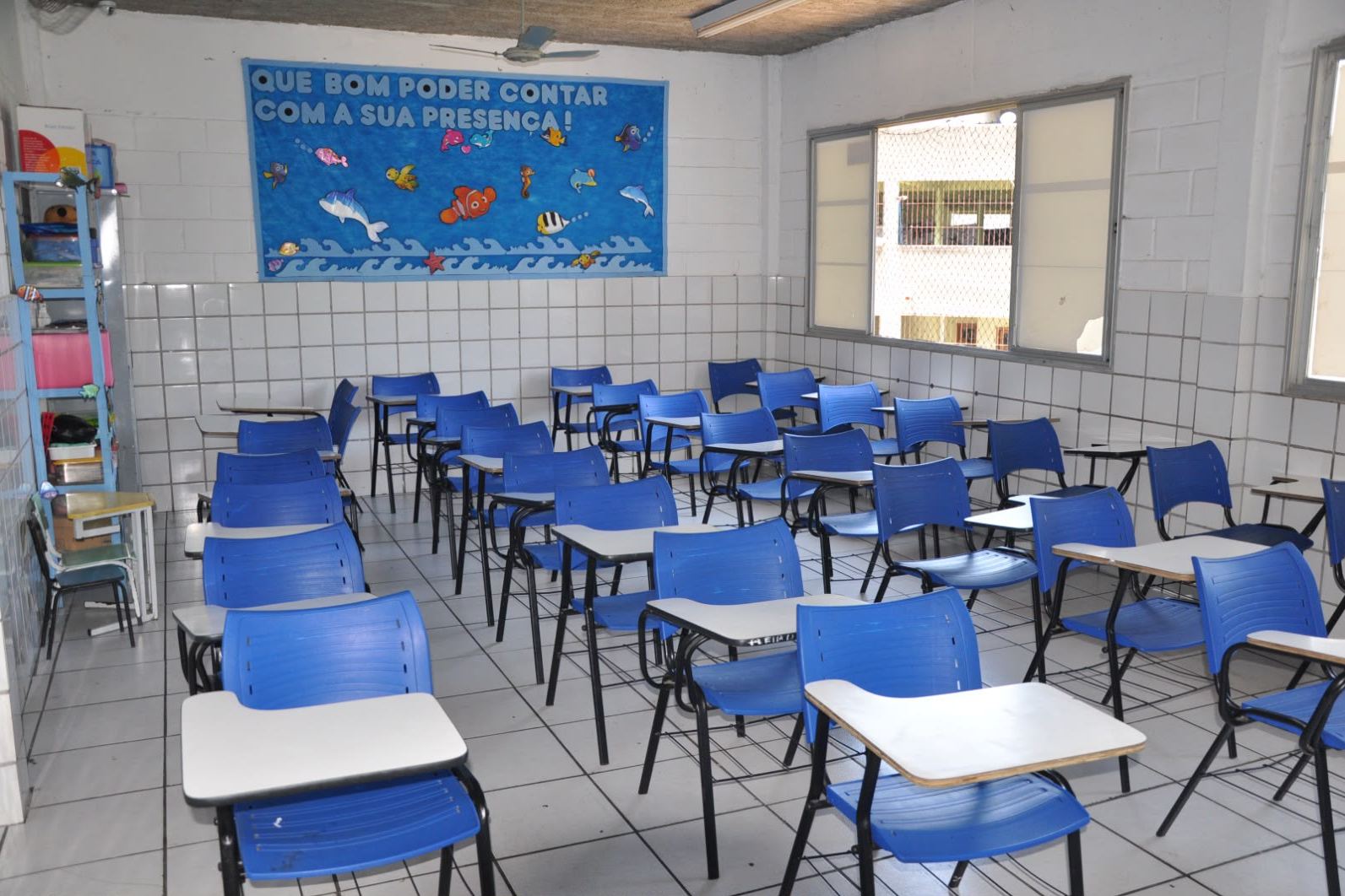 Sala de aula com carteiras e cadeiras azuis
